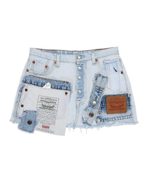 Light wash denim shorts with distressed details, frayed edges, and multiple leather patches including a Levi's waist patch and a brown brand patch on the pocket.