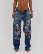 Le Pétite Jean distressed jeans showing a close-up of ripped denim with a casual, worn-in look.