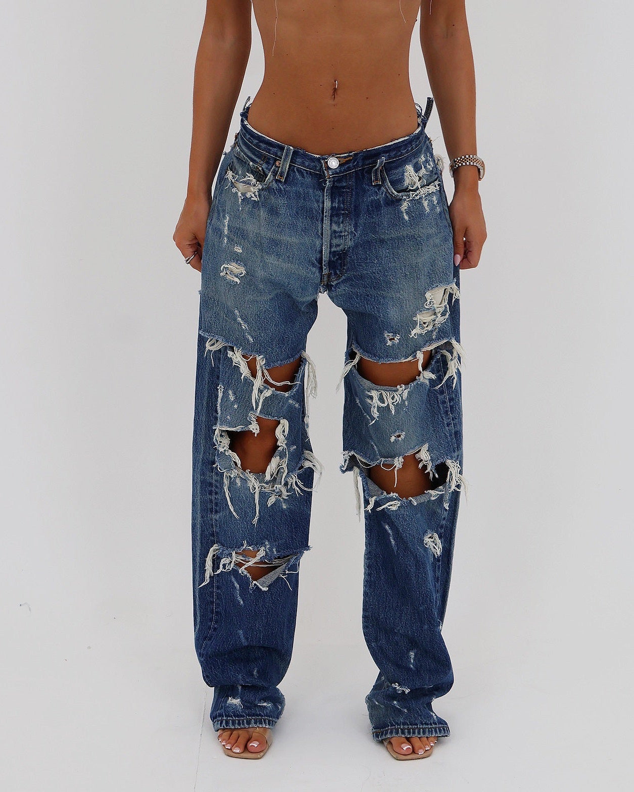 Le Pétite Jean distressed jeans showing a close-up of ripped denim with a casual, worn-in look.