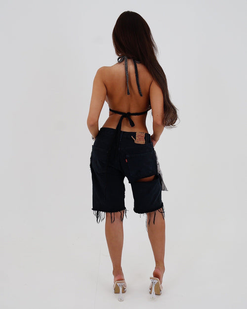 Black Le Pétite Jean After Hour Jorts, casual denim shorts with frayed hems and a relaxed fit, displayed on a hanger.