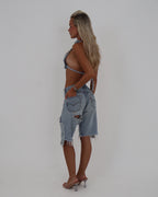 Le Pétite Jean The After Hour Jorts denim shorts with distressed details and frayed hem, model wearing casual summer shorts.