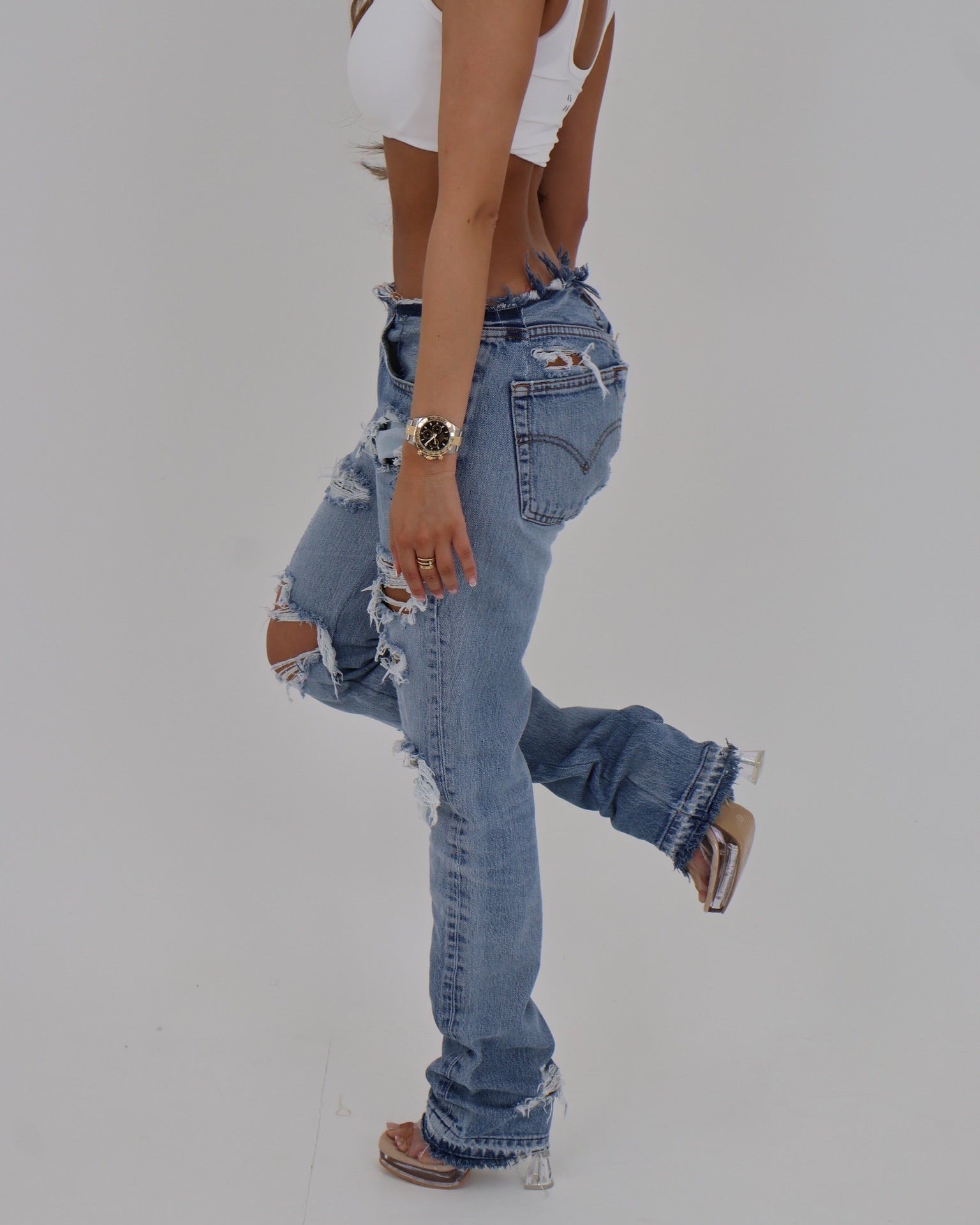Le Pétite Jean raw edge denim jeans featuring distressed hem and classic five-pocket style, displayed on a neutral background.